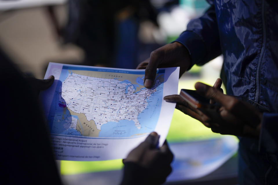 Migrants study a map of the United States at Friday, Oct. 6, 2023, in San Diego. San Diego's well-oiled system of migrant shelters is being tested like never before as U.S. Customs and Border Protection releases migrants to the streets of California's second-largest city because shelters are full. (AP Photo/Gregory Bull)