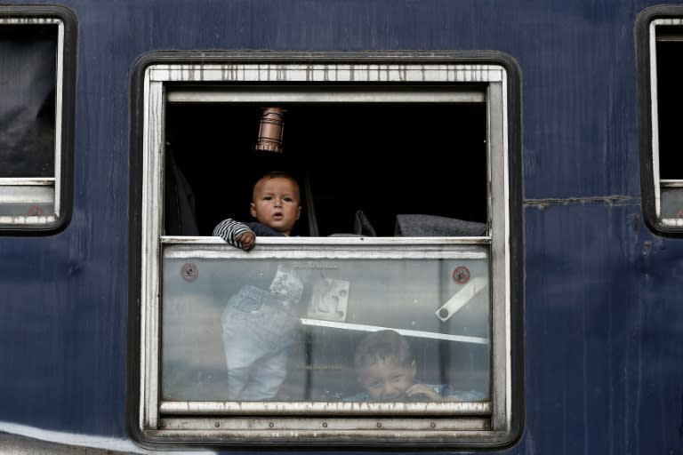 A child looks out of a window during a police operation to clear a makeshift camp for migrants near the village of Idomeni, northern Greece, on May 25, 2016