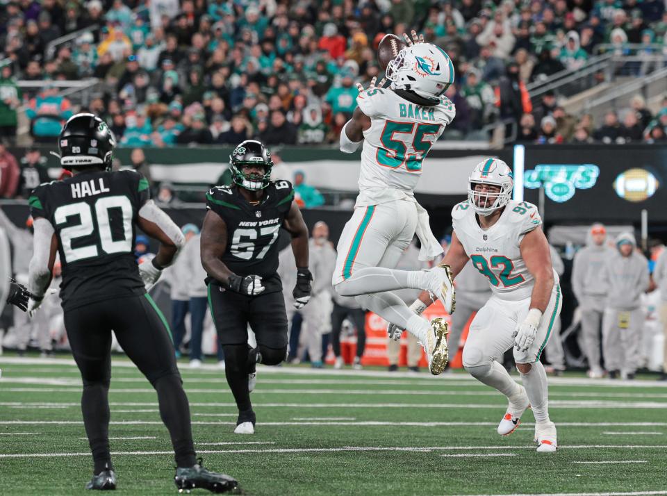 Nov 24, 2023; East Rutherford, New Jersey, USA; Miami Dolphins linebacker Jerome Baker (55) intercepts a pass in front of New York Jets running back Breece Hall (20) and offensive tackle Carter Warren (67) during the second half at MetLife Stadium. Mandatory Credit: Vincent Carchietta-USA TODAY Sports