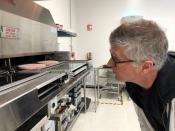 FILE PHOTO: Impossible Foods Chief Executive Pat Brown poses in front of a flame broiler cooking its plant-based patties at a facility in Redwood City