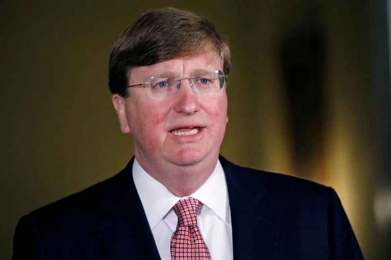 Mississippi Gov. Tate Reeves signs the bill retiring the last state flag in the United States with the Confederate battle emblem, during a ceremony at the Governor's Mansion in Jackson