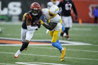 Cincinnati Bengals' Ja'Marr Chase (1) is tackled by Los Angeles Chargers' Tevaughn Campbell (20) during the second half of an NFL football game, Sunday, Dec. 5, 2021, in Cincinnati. (AP Photo/Michael Conroy)