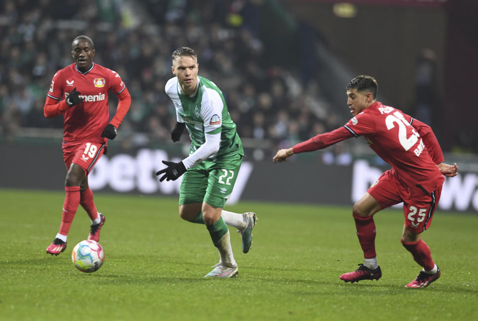 Werder's Niklas Schmidt, centre, vies for the ball with Leverkusen's Moussa Diaby, left and Exequiel Palacios, during the German Bundesliga soccer match between Werder Bremen and Bayer Leverkusen in Bremen, Germany, Sunday, March 12, 2023. (Carmen Jaspersen/dpa via AP)