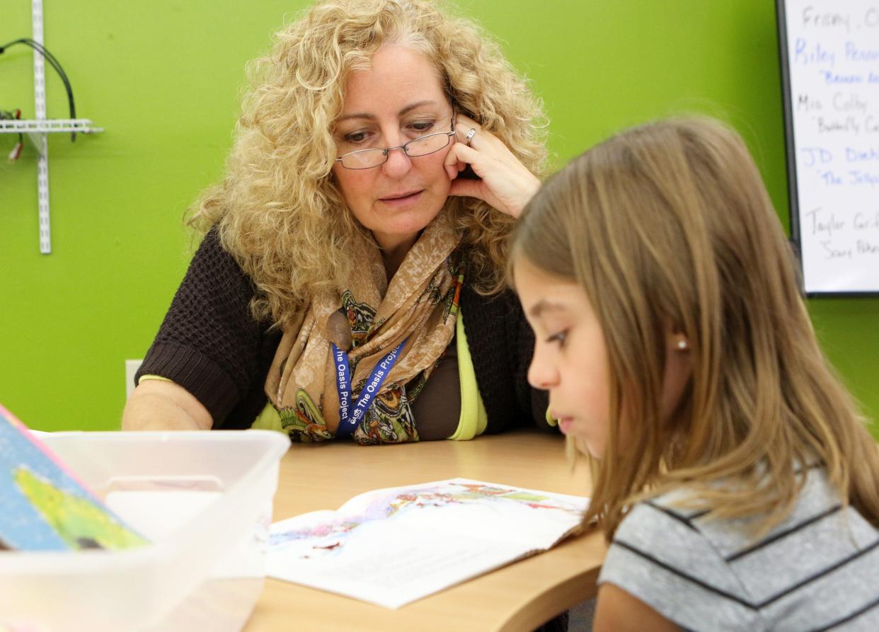 Oasis Project tutor Tresa Knutson works with a Dousman Elementary student as she reads the book "Red and Blue Mittens" in October 2016. Knutson, a retired Watertown teacher, is glad she found the Oasis Project, where she can still share her knowledge as a teacher.