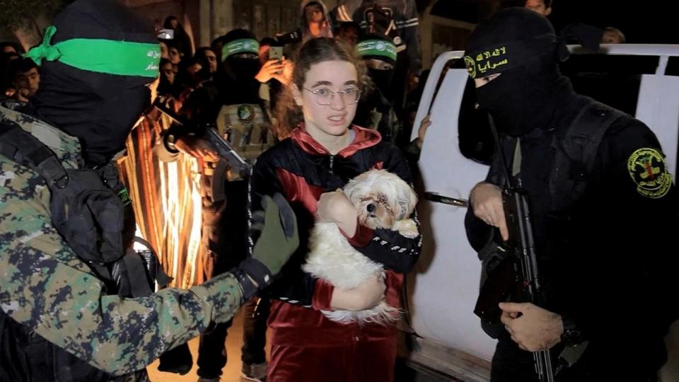 PHOTO: A hostage who was abducted by Hamas gunmen during the October 7 attack on Israel holds a dog while she and others are handed over by Hamas militants to members of the International Committee of the Red Cross in the Gaza Strip, Nov. 28, 2023. (Al-qassam Brigades via Reuters)