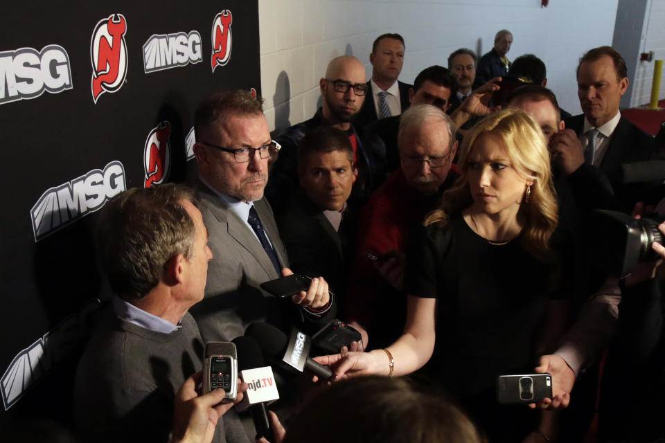 New Jersey Devils interim general Tom Fitzgerald, second from left, looks on as owner Josh Harris, left, speaks to announce Ray Shero was fired prior to an NHL hockey game Sunday, Jan. 12, 2020, in Newark, N.J. (AP Photo/Adam Hunger)