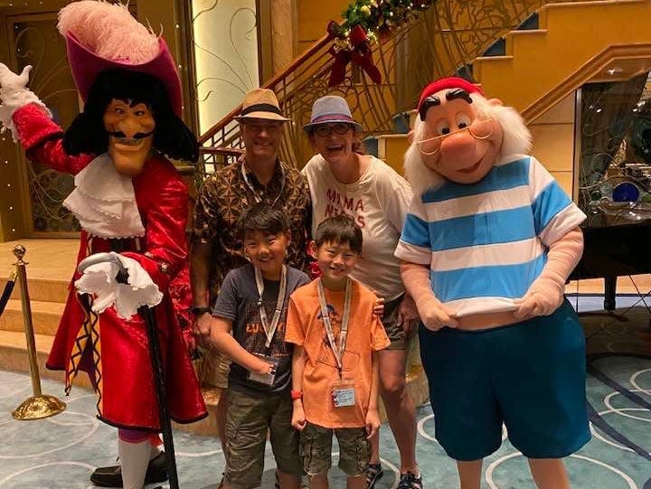 jill and her family posing with smee and captain hook on a disney cruise