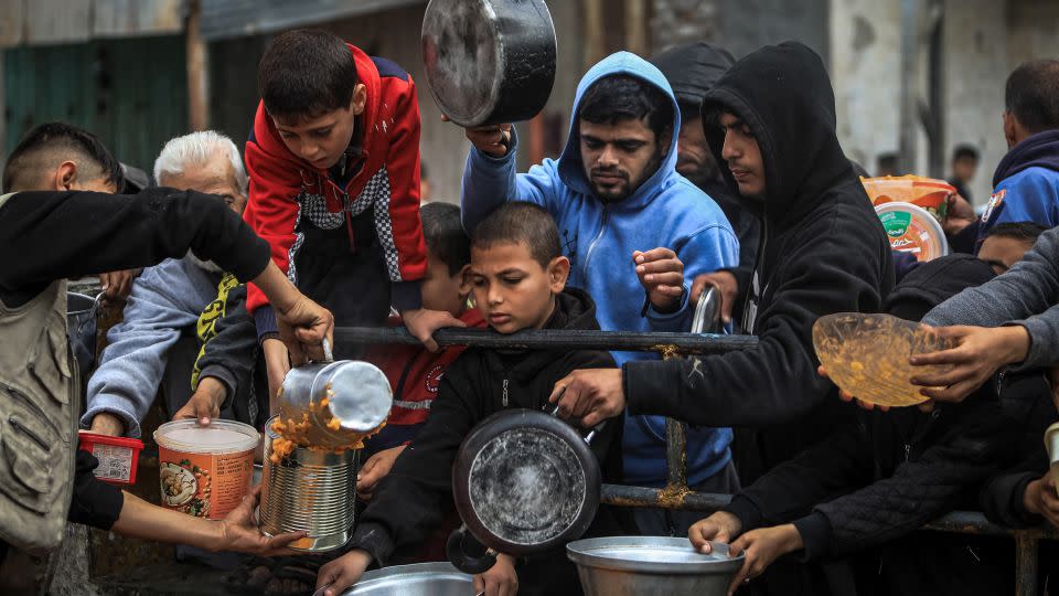 Displaced Palestinians receive food at a donation point in Rafah, southern Gaza, February 24, 2024. - Yasser Qudihe/Middle East Images/AFP/Getty Images