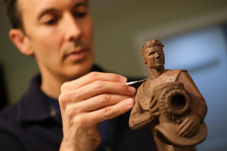 Artist Nathan Pratt is pictured Oct. 27 with examples of mock-up designs of a Wiley Post statue he wants to build on Edmond's east side off of State Highway 66 near Post Road.