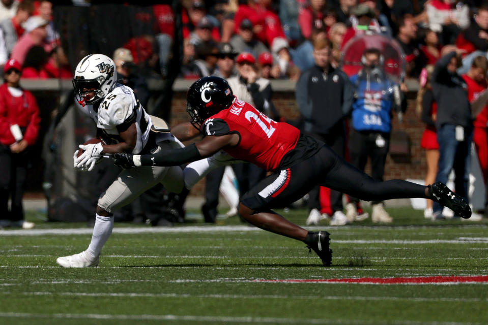 CINCINNATI, OHIO – OCTOBER 16: Johnny Richardson #25 of the <a class="link " href="https://sports.yahoo.com/ncaaf/teams/ucf/" data-i13n="sec:content-canvas;subsec:anchor_text;elm:context_link" data-ylk="slk:UCF Knights;sec:content-canvas;subsec:anchor_text;elm:context_link;itc:0">UCF Knights</a> runs with the ball while being chased by Jaheim Thomas #24 of the <a class="link " href="https://sports.yahoo.com/ncaaf/teams/cincinnati/" data-i13n="sec:content-canvas;subsec:anchor_text;elm:context_link" data-ylk="slk:Cincinnati Bearcats;sec:content-canvas;subsec:anchor_text;elm:context_link;itc:0">Cincinnati Bearcats</a> in the third quarter at Nippert Stadium on October 16, 2021 in Cincinnati, <a class="link " href="https://sports.yahoo.com/ncaaf/teams/ohio-st/" data-i13n="sec:content-canvas;subsec:anchor_text;elm:context_link" data-ylk="slk:Ohio;sec:content-canvas;subsec:anchor_text;elm:context_link;itc:0">Ohio</a>. (Photo by Dylan Buell/Getty Images)