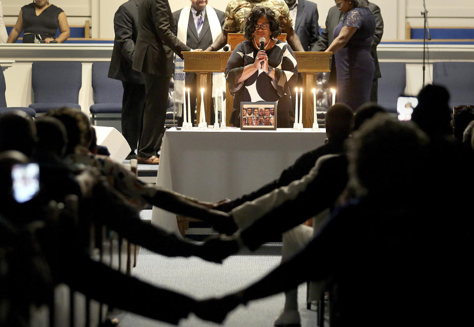 After lighting 12 candles, Veronica Coleman leads the congregation in prayer during a vigil for Ryan Keith Cox at the Piney Grove Baptist Church in Virginia Beach, Va., June 2, 2019. (Photo: Rob Ostermaier/AP)