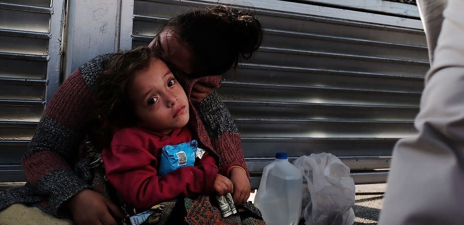 A Honduran child and her mother, fleeing poverty and violence in their home country, wait along the border bridge after being denied entry into the U.S.