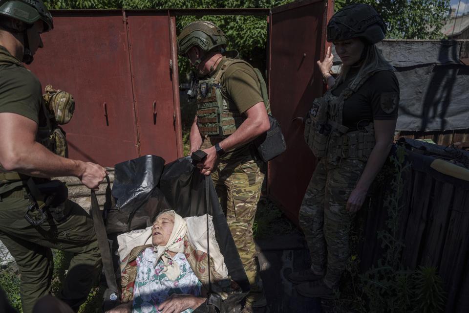 Police officers from the White Angels unit carry a woman on a stretcher to a waiting van during evacuation to safe areas, in Toretsk, Donetsk region, Ukraine, June 28, 2024. (AP Photo/Evgeniy Maloletka)