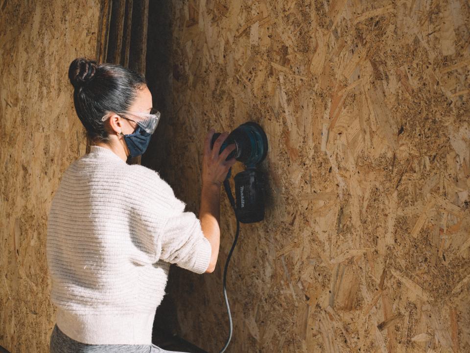 Eugenia sanding down the interior walls of the cabin.