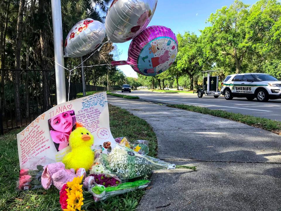 Cars drive by a memorial Thursday for Tiana Johnson, 15, one of four children hit by a car as they waited for their school bus at the corner of Crestwood Boulevard and Cypress Lake Drive in Royal Palm Beach.