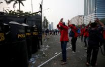 FILE PHOTO: University students gesture in front of police officers as they protest outside the Indonesian Parliament in Jakarta