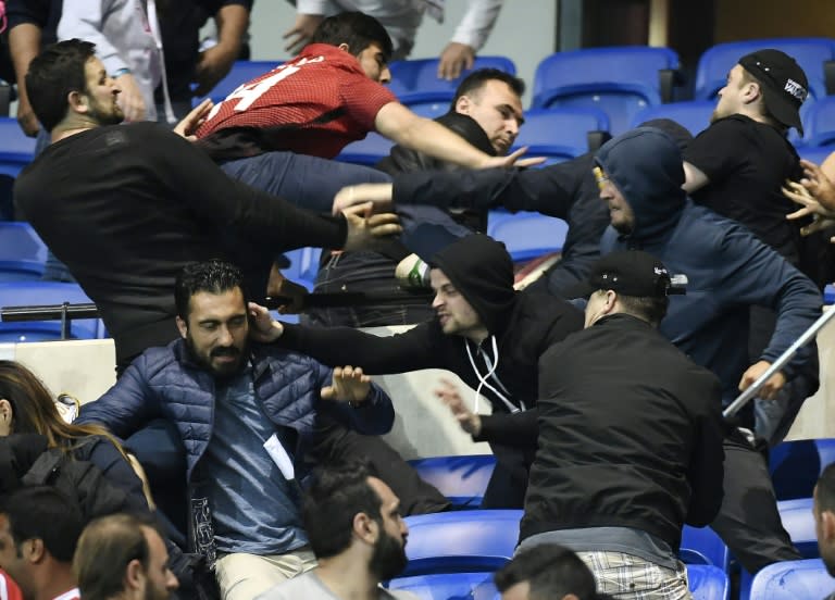 Besiktas' and Lyon's supporters fight before their UEFA Europa League first leg quarter final football match on April 13, 2017, at the Parc Olympique Lyonnais stadium in Decines-Charpieu, central-eastern France