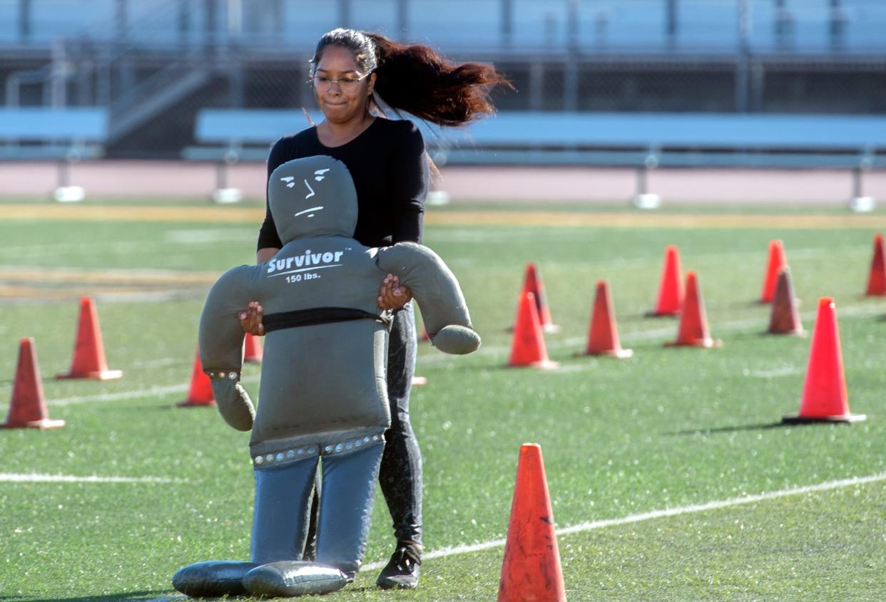 Cynthia Rubio carries a dummy while participating in the Stockton Police Department's recruit testing which consisted of an obstacle course, a 1/2-mile run and a written test at the Stagg High School football field in Stockton on Saturday, August 13, 2022.