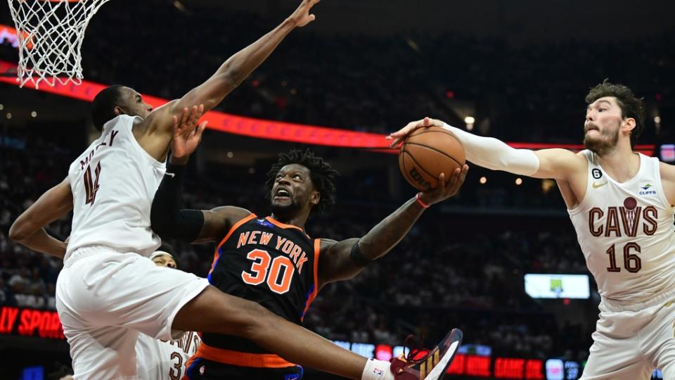 Apr 18, 2023; Cleveland, Ohio, USA; New York Knicks forward Julius Randle (30) drives to the basket between Cleveland Cavaliers forward Evan Mobley (4) and forward Cedi Osman (16) during the second quarter of game two of the 2023 NBA playoffs at Rocket Mortgage FieldHouse.