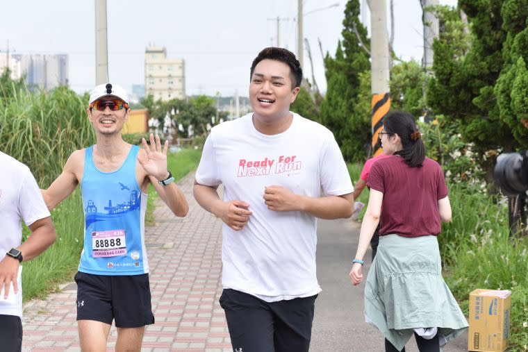 賽道上跑者們幫關韶文(中)加油，日本跑者Tomo桑還折返陪跑。大會提供