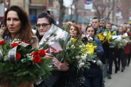 A cortege escorts a car carrying the coffin with the body of Oliver Ivanovic, flanked by priests and family, to the northern outskirts of Kosovska Mitrovica, Kosovo January 17, 2018. REUTERS/Djordje Kojadinovic