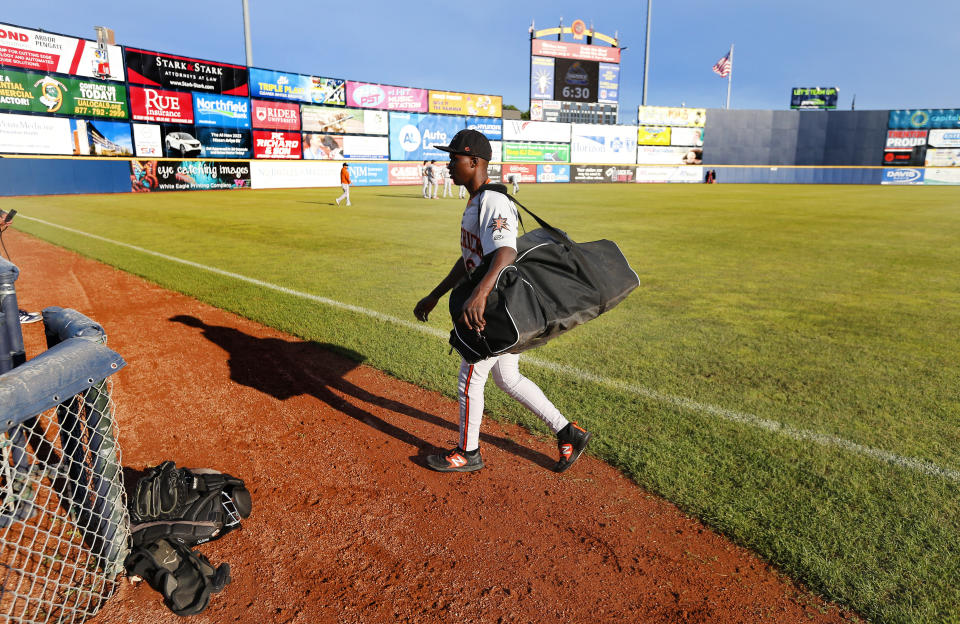 Frederick Keys catcher Dennis Kasumba walks to bullpen before the team's baseball game against the Trenton Thunder, Tuesday, July 4, 2023, in Trenton, N.J. Kasumba, from Uganda, dreams of reaching the major leagues someday. The 19-year-old catcher had a chance to play for the Frederick Keys of the MLB Draft League this past month. (AP Photo/Noah K. Murray)