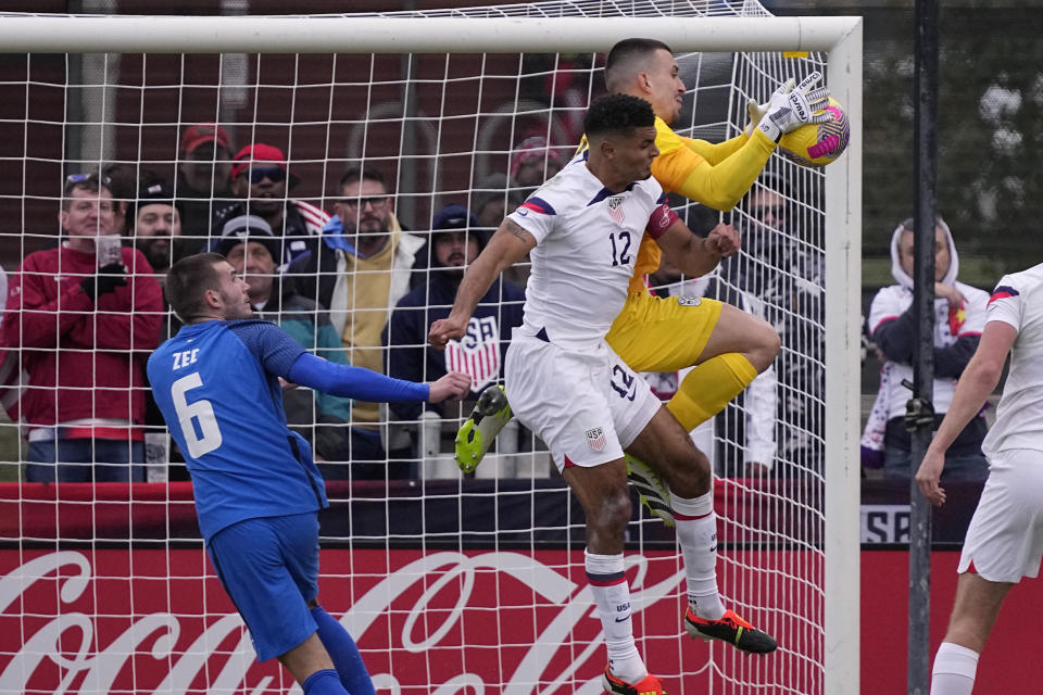 Slovenia goalkeeper Igor Vekic, right, leaps in front of United States defender Miles Robinson (12) to stop a shot on goal during the second half of an international friendly soccer match in San Antonio, Saturday, Jan. 20, 2024. (AP Photo/Eric Gay)