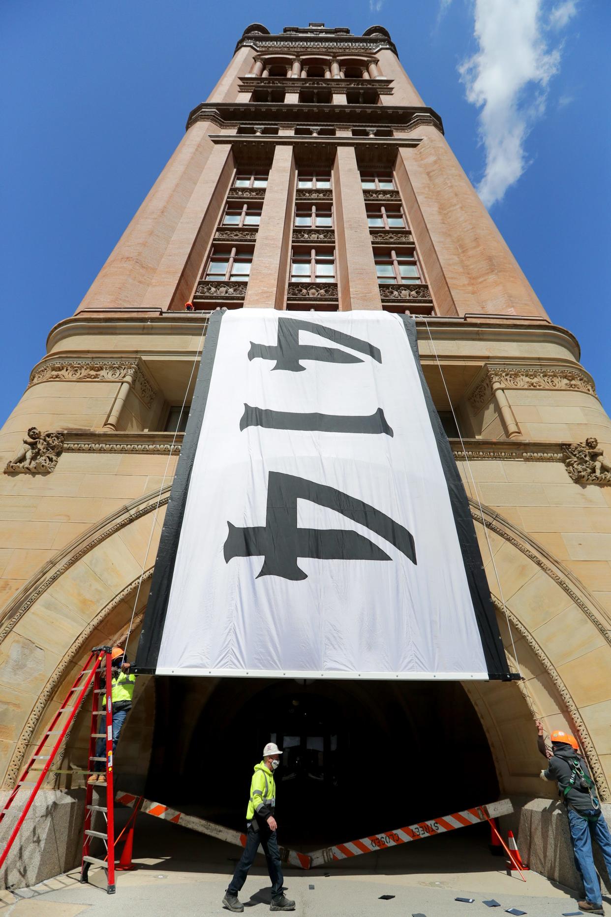 A giant 414 flag is unveiled from the balcony of Milwaukee City Hall on Monday, April 12, 2021. Milwaukee will celebrate Milwaukee Day on Wednesday, April 14, the same collection of digits as the area code for Milwaukee.