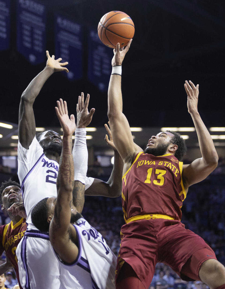 Iowa State's Jaren Holmes, right, shoots over Kansas State's Desi Sills, bottom, and Abayomi Iyiola during the first half of an NCAA college basketball game on Saturday, Feb. 18, 2023, in Manhattan, Kan. (AP Photo/Travis Heying)