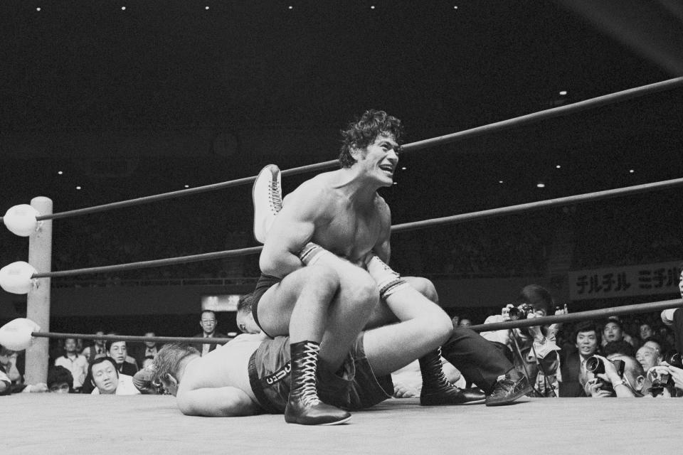 CORRECTS TO 1976, NOT 1979 - FILE - Japanese pro wrestler Antonio Inoki clamps leg hold on boxer Chuck Wepner of Bayonne, New Jersey, during the sixth round of a bout at Tokyo's Budokan hall on Oct. 26, 1977. A popular Japanese professional wrestler and lawmaker Antonio Inoki, who faced a world boxing champion Muhammad Ali in a mixed martial arts match in 1976, has died at 79. The New Japan Pro-Wrestling Co. says Inoki, who was battling an illness, died earlier Saturday, Oct. 1, 2022. (AP Photo, File)