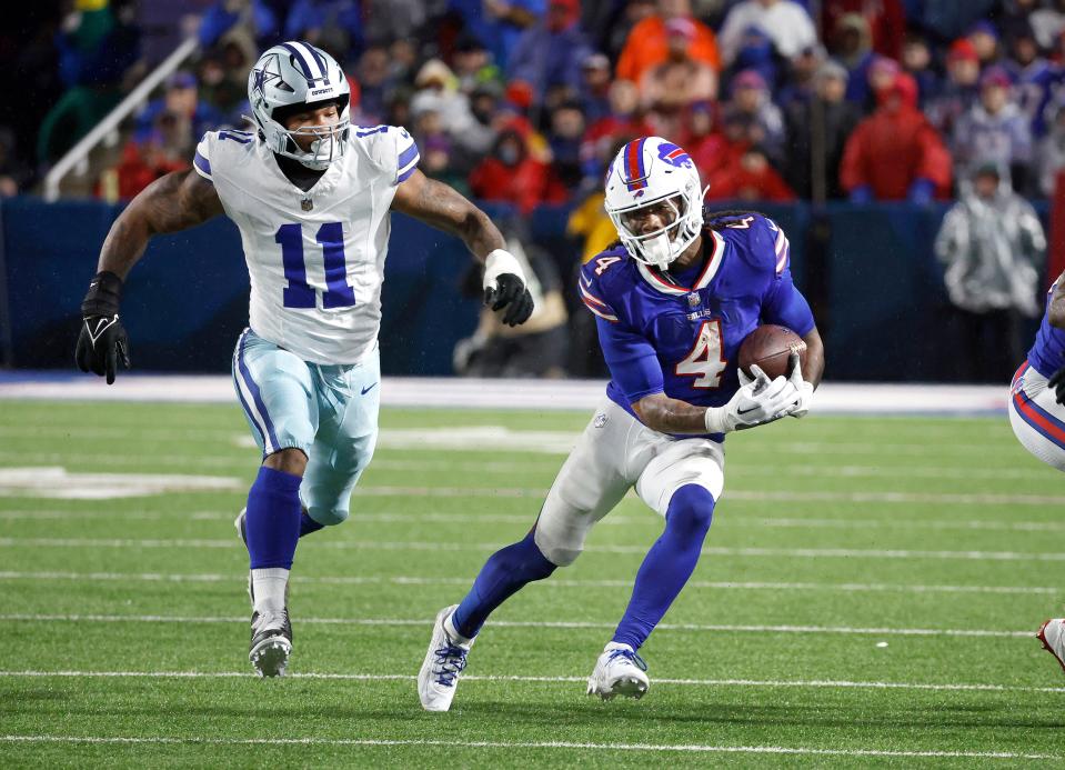 Buffalo Bills running back James Cook (4) gets extra yards as he runs past Dallas Cowboys linebacker Micah Parsons (11). Cook rushed for 179 yards in a 31-10 win.