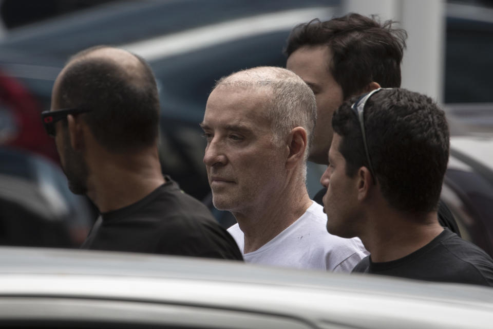 FILE - In this Jan. 31, 2017 file photo, businessman Eike Batista is escorted as he arrives at the Federal Police headquarters in Rio de Janeiro, Brazil. Police arrested the oil and mining mogul who was once Brazil's richest man on corruption charges, as a string of newly approved plea bargains threatened to draw more top politicians and executives into a massive graft probe. (AP Photo/Felipe Dana, File)