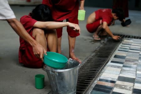 Patients react after drinking a vomit-inducing medication made with plants and roots at the rehabilitation and detox area at Wat Thamkrabok monastery in Saraburi province, Thailand, February 7, 2017. REUTERS/Jorge Silva