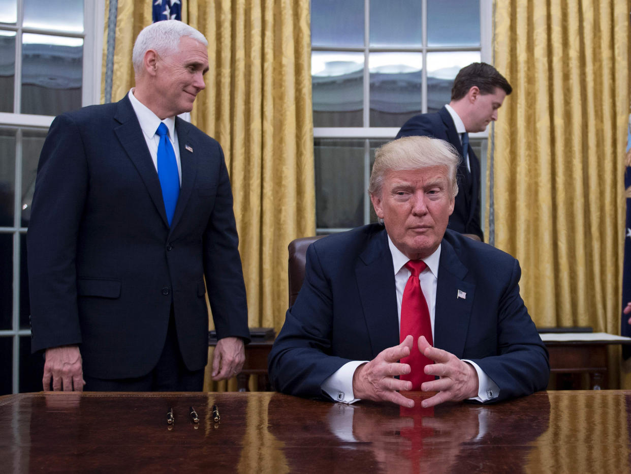 Donald Trump sits in the Oval Office for the first time, flanked by his Vice President Mike Pence and White House Chief of Staff Reince Priebus: Jim Watson/AFP/Getty