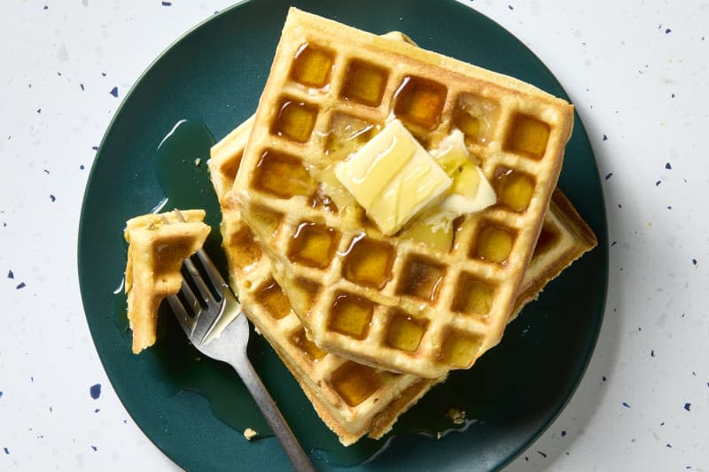 overhead shot of two waffles stacked on each other, with a bite taken from it.
