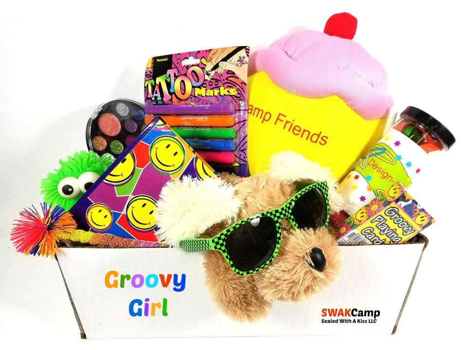 In this Jan. 30, 2017 photo provided by Sealed With A Kiss, toys and games that go into a Groovy Girl camp care package by Sealed With A Kiss are shown. (Sealed With A Kiss via AP)