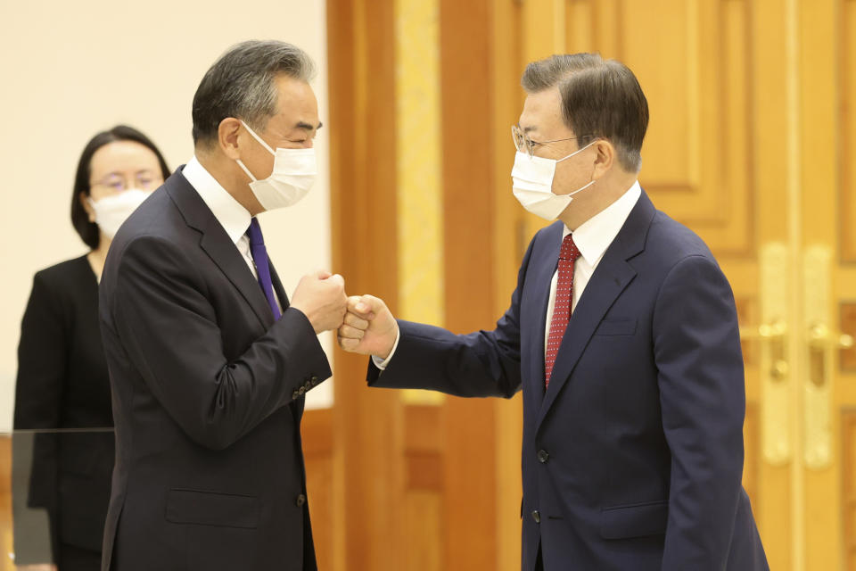 South Korean President Moon Jae-in, right, greets with Chinese Foreign Minister Wang Yi prior to a meeting at the presidential Blue House in Seoul, South Korea, Wednesday, Sept. 15, 2021. Wang was to hold a meeting with his South Korean counterpart for talks expected to focus on North Korea and other regional security issues. (Choi Jae-ku/Yonhap via AP)