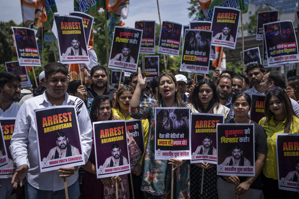 FILE- Supporters of opposition Congress party hold placards during a protest rally against the wrestling federation chief over allegations of sexual harassment in New Delhi, India, June 1, 2023. New Delhi police filed charges Thursday of sexual harassment and outraging the modesty of six female athletes by Indian wrestling federation president Brij Bhushan Sharan Singh at the end of their investigation.If convicted, Singh faces a maximum of five years in prison. He denies the allegations. (AP Photo/Altaf Qadri, File)