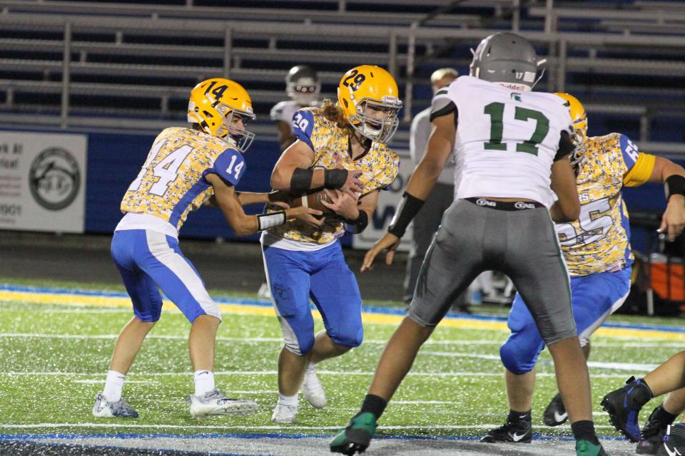 Clyde's Brennan Wilson hands the ball to Clark Norman.