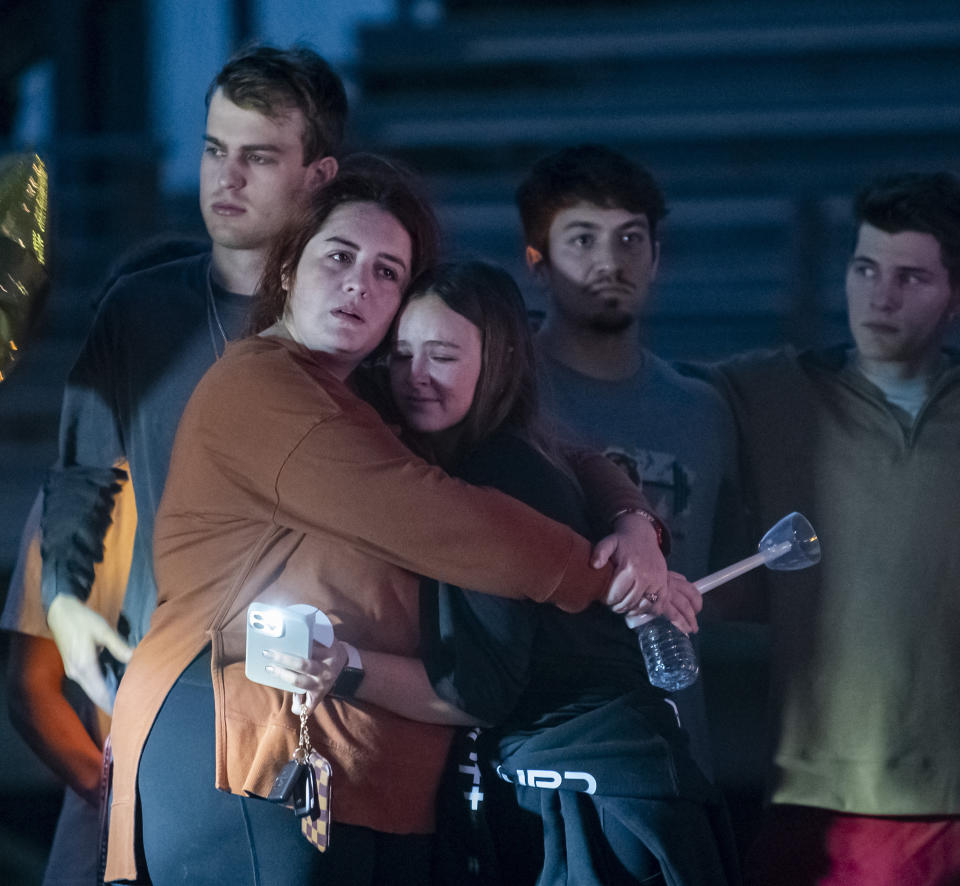 Family members of Maggie Dunn hug during the Candlelight vigil for Dunn and Caroline Gill on Monday, Jan. 2, 2023 in Brusly, La. A police officer has been charged over his role in the death of two teenagers during the high-speed pursuit of a home-invasion suspect in Louisiana. (Michael Johnson/The Advocate via AP)