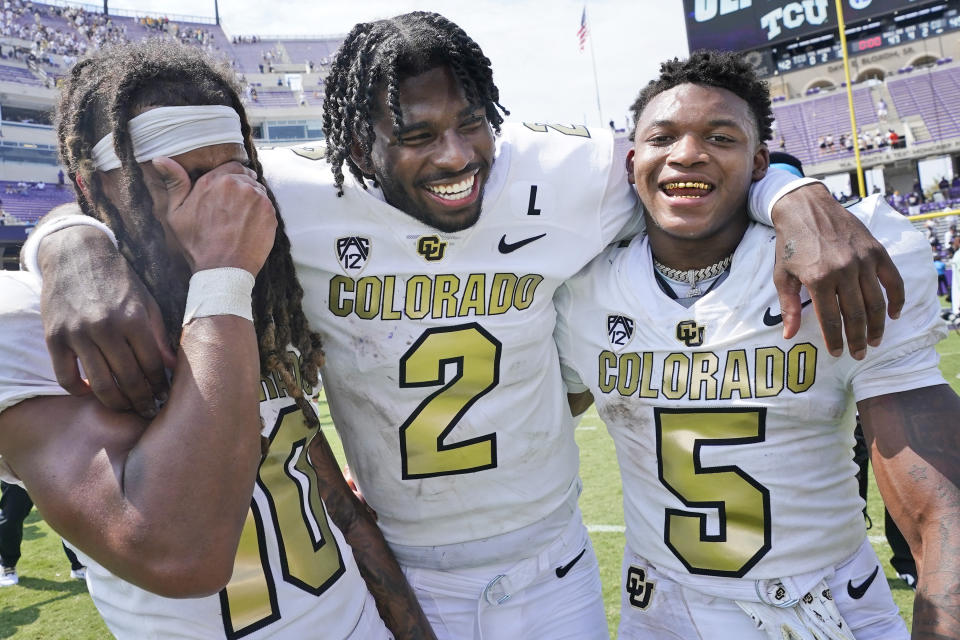 Colorado quarterback Shedeur Sanders (2) embraces wide receivers Xavier Weaver (10) and Jimmy Horn Jr. (5) after an NCAA college football game Saturday, Sept. 2, 2023, in Fort Worth, Texas. (AP Photo/LM Otero)