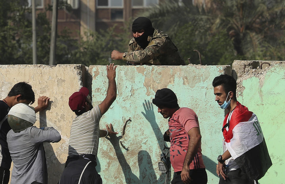 Iraqi security forces try to disperse anti-government protesters in downtown Baghdad, Iraq, Wednesday, Nov. 13, 2019. (AP Photo/Hadi Mizban)