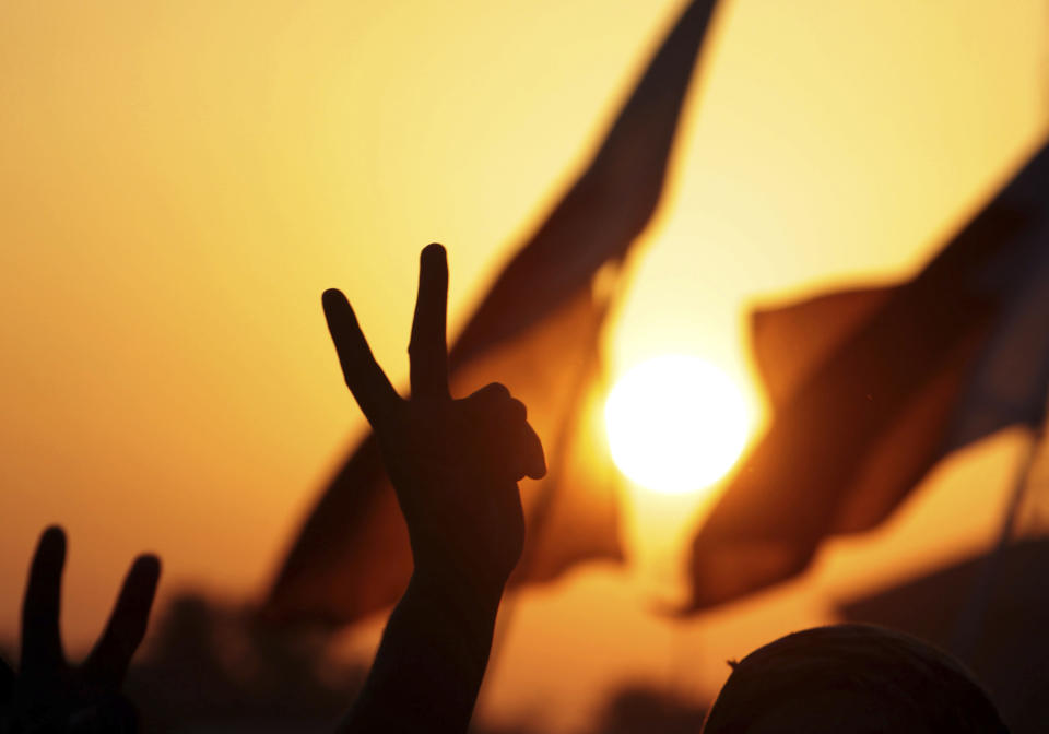 FILE - Anti-government protesters wave Bahraini flags and gesture as they participate in a rally and march Friday, Nov. 25, 2011, that drew tens of thousands to Maqsha, Bahrain. Hackers said they had taken down the website of Bahrain's international airport on Tuesday, Feb. 14, 2023, to mark the 12-year anniversary of an Arab Spring uprising in the small Gulf country. (AP Photo/Hasan Jamali, File)