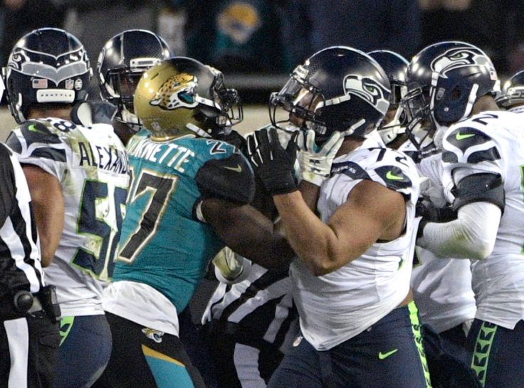 Jacksonville running back Leonard Fournette (27) and Seattle defensive end Michael Bennett (72) shove each other during a scrum between the two teams near the end of the game after Bennett rolled into the knees of a Jaguars player. (AP)