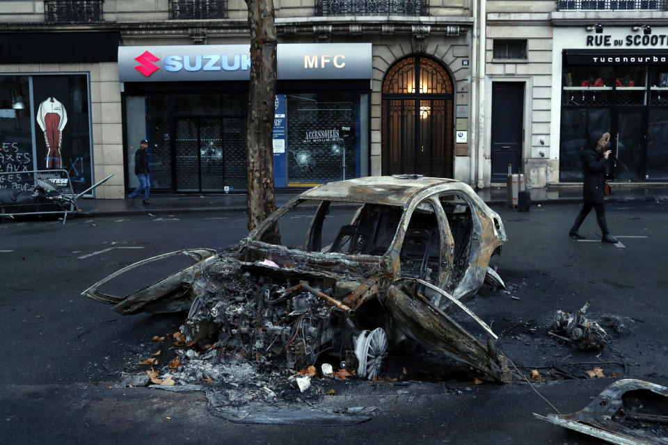 A charred car is pictured the day after a demonstration, near the Arc de Triomphe, in Paris, Sunday, Dec. 2, 2018. A protest against rising taxes and the high cost of living turned into a riot in the French capital, as activists torched cars, smashed windows, looted stores and tagged the Arc de Triomphe with multi-colored graffiti. (AP Photo/Thibault Camus)