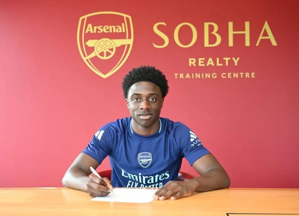 Ismeal Kabia signs his contract with Arsenal (Photo via Arsenal.com)