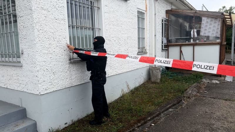 A police officer applies flutter tape to cordon off the premises of the Islamic Center in Fuerstenwalde during a search. Brandenburg's Interior Minister Stuebgen has banned the Islamic Center Fuerstenwalde al-Salam association. The association in the Oder-Spree district of Brandenburg is directed against "the idea of international understanding and the constitutional order", according to the statement. Lutz Deckwerth/dpa