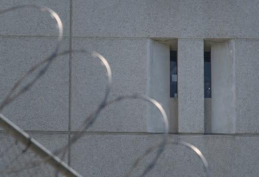 A detainee shines a torch from the main ICE detention center in downtown Los Angeles in 2019