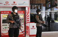 Police officers stand guard at the Ngurah Rai airport, Friday, April 24, 2020, in Bali, Indonesia. Indonesia is suspending passenger flights and rail service as it restricts people in the world's most populous Muslim nation from traveling to their hometowns during the Islamic holy month of Ramadan because of the coronavirus outbreak. (AP Photo/Firdia Lisnawati)