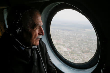 Ukrainian military pilot Mykola Volkozub, who was deployed in a team to fly a helicopter over the reactor to measure the temperature and composition of gases after the accident at the Chernobyl nuclear power plant in 1986, looks on during a flight inside a Mi-8 helicopter in Kiev Region, Ukraine April 24, 2018. REUTERS/Valentyn Ogirenko